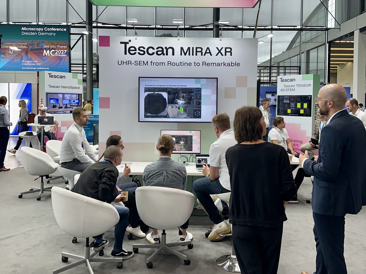 Visitors at a live product demonstration on a large trade fair stand